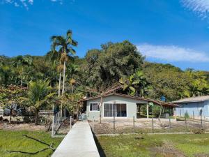 een huis met palmbomen en een stoep bij Sonho do Mar in Antonina