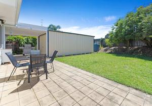 a patio with a table and chairs in a yard at The Nook - Lake Illawarra in Lake Illawarra
