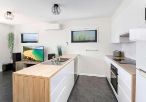 a kitchen with white walls and a wooden counter top at The Nook - Lake Illawarra in Lake Illawarra
