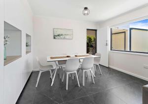 a dining room with a white table and chairs at The Nook - Lake Illawarra in Lake Illawarra +16 photos