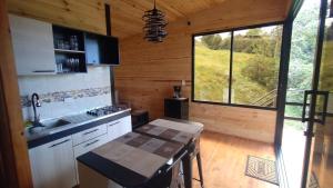 a kitchen with a large window in a log cabin at La Cabaña de Jofiel in Supatá