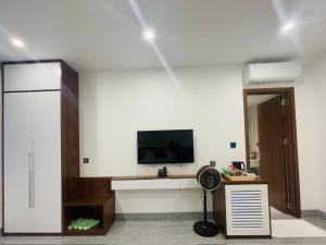 a living room with a television and a desk with a fan at Tâm Khang Hotel in Móng Cái
