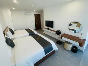 a hotel room with two beds and a television at Tâm Khang Hotel in Móng Cái +23 photos