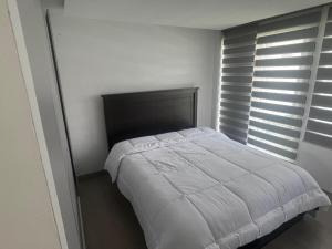 Un dormitorio con una cama con una manta blanca. en Entire house with a pool for total relaxation!,  22 fotos más