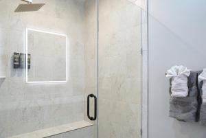 Un baño con ducha con puerta de cristal. en Modern Escape Steps from FedEx Field & Near DC, en Largo 22 fotos más
