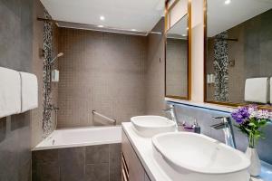 a bathroom with two sinks and a bath tub at Hotel Purple Hong Kong in Hong Kong