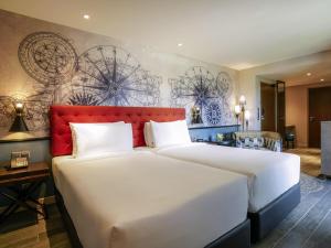 a bedroom with a large bed with a red headboard at Mercure Langkawi Pantai Cenang in Pantai Cenang +109 photos