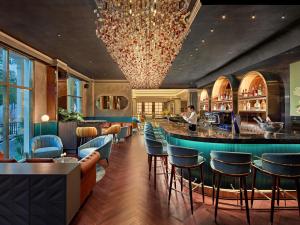 a bar in a restaurant with blue chairs at Mövenpick Hotel Hanoi Centre in Hanoi
