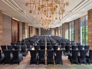 una gran sala de conferencias con sillas y una lámpara de araña. en Mövenpick Hotel Hanoi Centre, en Hanói