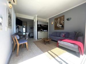 a living room with a blue couch and a table at Villa Aqua at Palm Beach in Waiheke Island