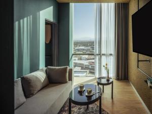 a living room with a couch and a large window at Novotel Mexico City Toreo in Mexico City