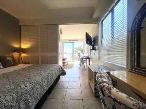 a bedroom with a bed and a table and a chair at Villa Aqua at Palm Beach in Waiheke Island +10 photos