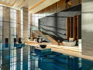 a hotel lobby with a swimming pool and stairs at Fairmont Riyadh in Riyadh