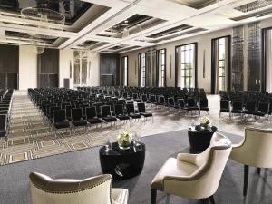 利雅德Fairmont Riyadh的一间空房间,摆放着一排椅子和桌子 更多150张照片