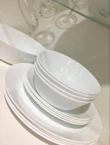 een stapel witte borden op een tafel bij 2BR Trafalgar Retreat near UBC & Pacific Spirit in Vancouver