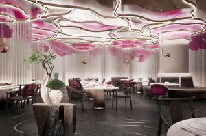 a dining room with tables and chairs and a colorful ceiling at The Reserve Hotel Luoyang, Curio Collection By Hilton in Luoyang