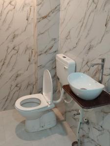a bathroom with a white toilet and a sink at Krishna dormitory & rooms Varanasi nearby ghat in Varanasi