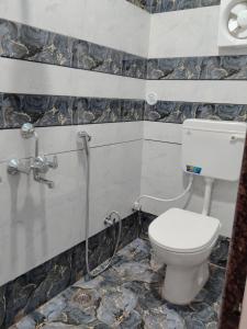 a bathroom with a toilet and a shower at Krishna dormitory & rooms Varanasi nearby ghat in Varanasi +4 photos