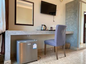 a bar in a room with a chair and a television at YES Apartments in Ban Saiyuan (1)