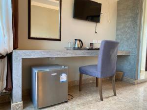 a desk with a chair and a television in a room at YES Apartments in Ban Saiyuan (1)