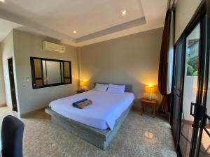 a bedroom with a large white bed and a window at YES Apartments in Ban Saiyuan (1)