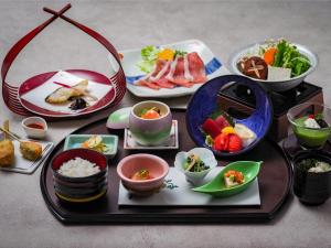 a table topped with plates and bowls of food at Manza Prince Hotel in Tsumagoi +80 photos