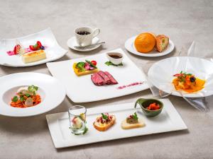a table with plates of food and a cup of coffee at Manza Prince Hotel in Tsumagoi