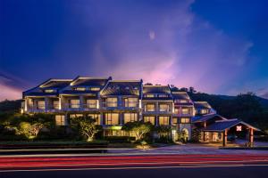 a large building is lit up at night at Hilton Garden Inn Zhoushan Mount Putuo in Zhoushan