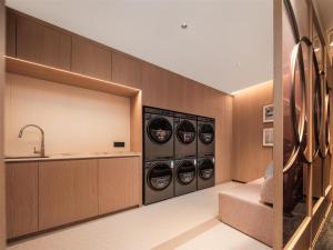 a laundry room with four washing machines and a sink at Hilton Garden Inn Zhoushan Mount Putuo in Zhoushan