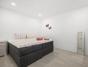 - un petit lit dans une chambre dotée d'un mur blanc dans l'établissement Luxe Huis Met Privzwembad Villapark Fontein, à Fontein 23 autres photos