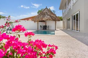 une villa avec une piscine et des fleurs roses dans l'établissement Luxe Huis Met Privzwembad Villapark Fontein, à Fontein
