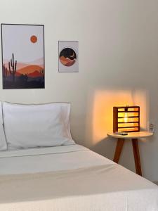 a bedroom with a bed and a nightstand next to a bed sidx sidx sidx at Maruá Pousada da Lagoa in Jijoca de Jericoacoara