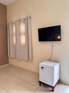 a white refrigerator in a room with a flat screen tv at Maruá Pousada da Lagoa in Jijoca de Jericoacoara