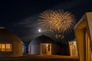 ein Feuerwerk über einer Kuppelsternwarte bei Nacht in der Unterkunft URUMA DOME Neptune9 in Uruma