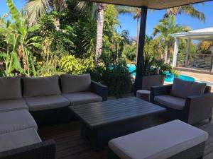 a patio with a couch and a table and chairs at villa Whakata in Saint-Leu