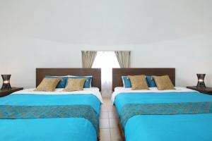 zwei nebeneinander stehende Betten in einem Schlafzimmer in der Unterkunft URUMA DOME Neptune9 in Uruma