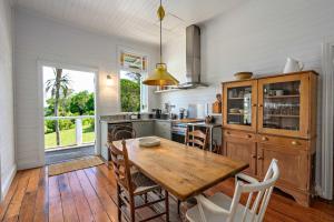 a kitchen with a wooden table and some chairs at Hinterland Retreat l Fire Pit Scenic Views l Nova Escapes in Goonengerry