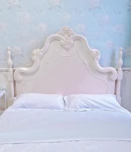 uma cama branca com uma cabeceira branca e almofadas brancas em Ding Ding Warm Home em Nanquim mais 23 fotografias