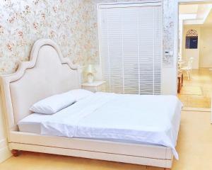 a white bed in a bedroom with a window at Ding Ding Warm Home in Nanjing
