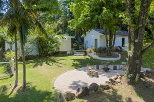 a yard with trees and a house with a patio at Romantic Escape l Firepit & Views l Nova Escapes in Goonengerry