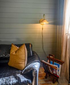 a living room with a leather couch and a lamp at Byron Hinterland Hideaway l Firepit l Nova Escapes in Goonengerry +61 photos
