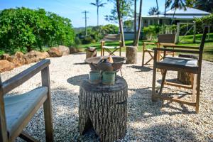 a table with two cups on top of a tree stump at Romantic Escape l Firepit & Views l Nova Escapes in Goonengerry