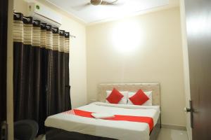 ein Schlafzimmer mit einem Bett mit roten Kissen in der Unterkunft Hotel O Hmi International in Meerut