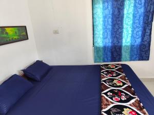 アランボールにあるSree Sai guest houseのベッドルーム1室(青いベッド1台、青い枕付)