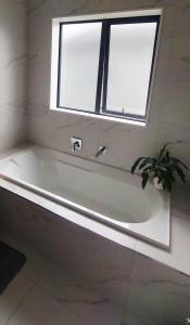 una bañera en un baño con ventana en Nature Escape Near Orewa Beach, en Silverdale