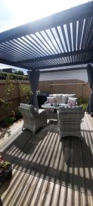 Un patio con dos sillas y una mesa bajo un dosel azul. en Nature Escape Near Orewa Beach, en Silverdale