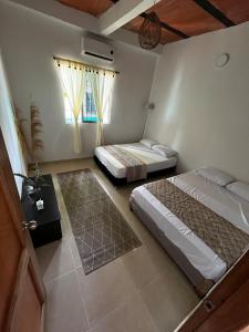 une chambre avec deux lits et une fenêtre dans l'établissement Isla Rosa, à Coveñitas