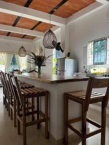 une cuisine avec un comptoir avec des chaises et un îlot de cuisine dans l'établissement Isla Rosa, à Coveñitas