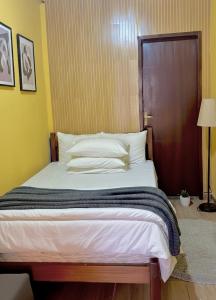 a bedroom with a large bed with white pillows at Chêles - Casa na Praia do taquari in Paraty