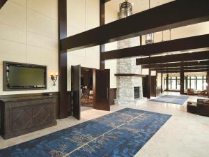 un salon avec une télévision et une cheminée dans l'établissement Fairmont Le Chateau Montebello, à Montebello